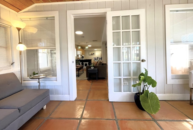 entryway featuring tile patterned flooring, wooden ceiling, and vaulted ceiling