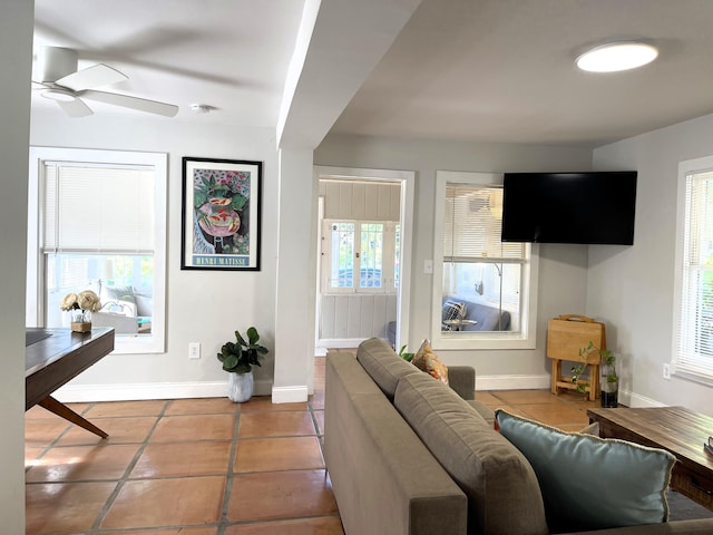 tiled living room featuring a ceiling fan and baseboards