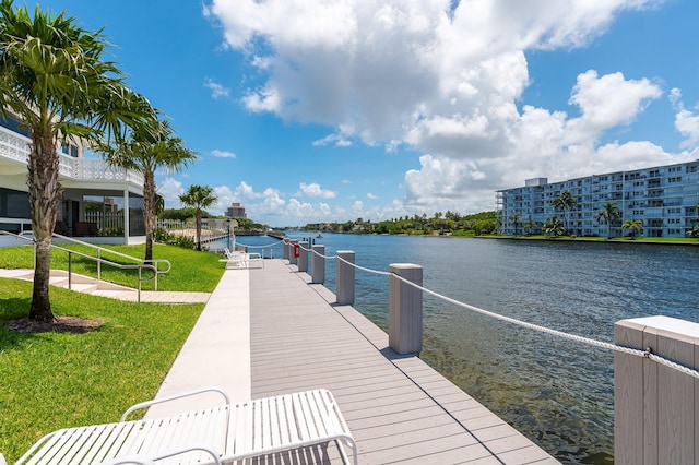 view of dock with a yard and a water view