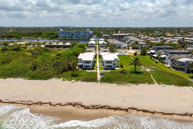 birds eye view of property featuring a beach view and a water view