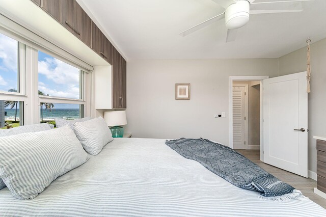 bedroom with light hardwood / wood-style flooring, ceiling fan, and a wall unit AC