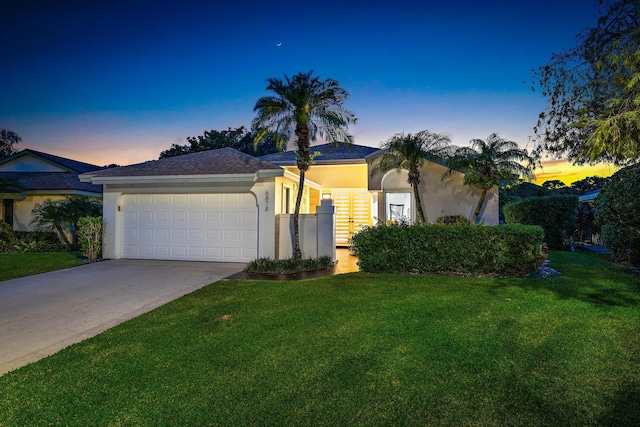 view of front of property featuring a garage and a yard