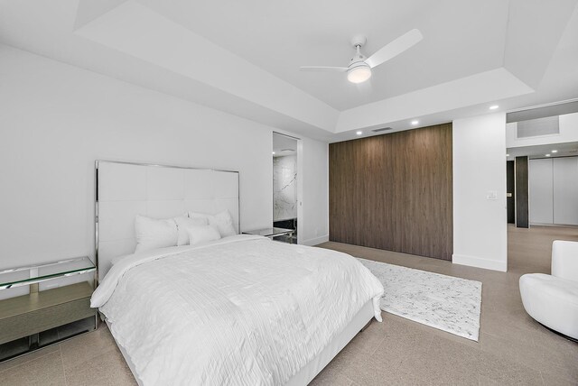 bedroom with ceiling fan and a tray ceiling