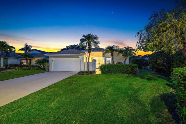 view of front of house with a garage and a yard