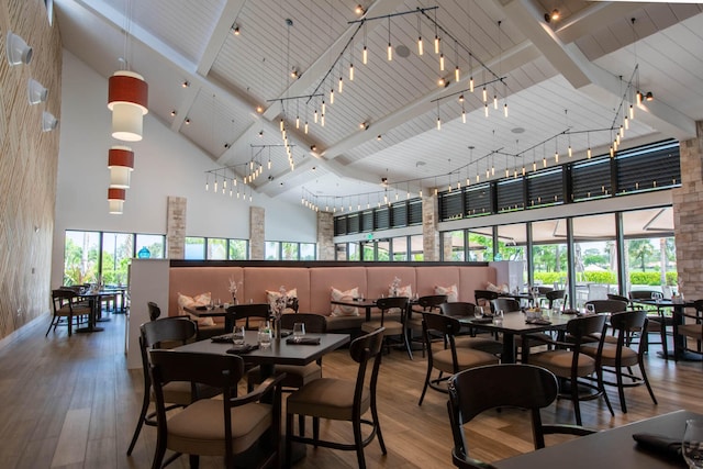 dining space featuring high vaulted ceiling and hardwood / wood-style floors