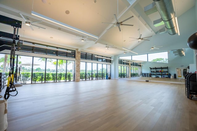 exercise room featuring a high ceiling and light wood-type flooring