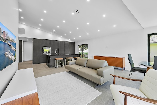 living room with sink and high vaulted ceiling