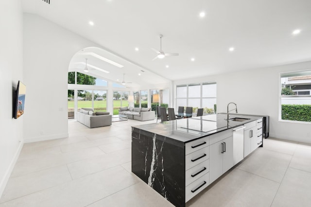 kitchen featuring a kitchen island with sink, ceiling fan, white cabinets, lofted ceiling, and sink