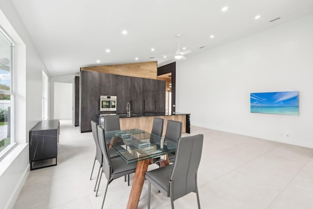 dining space with sink, ceiling fan, and vaulted ceiling