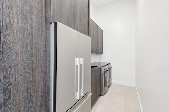 kitchen featuring high end fridge, washer and dryer, and light tile patterned floors