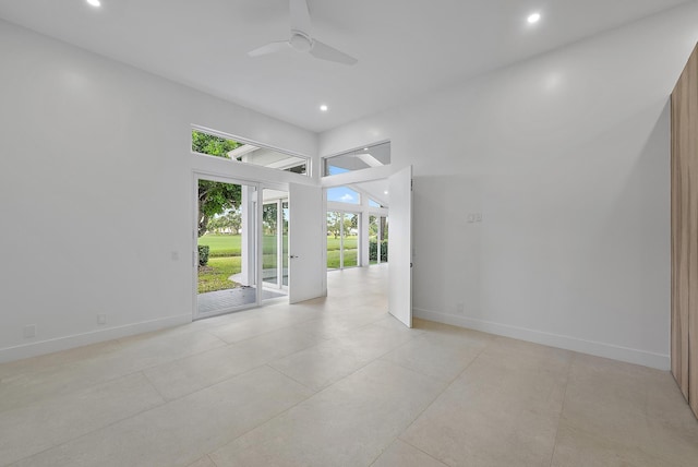 spare room featuring ceiling fan and a high ceiling