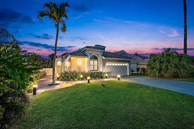 mediterranean / spanish home with a lawn and a garage