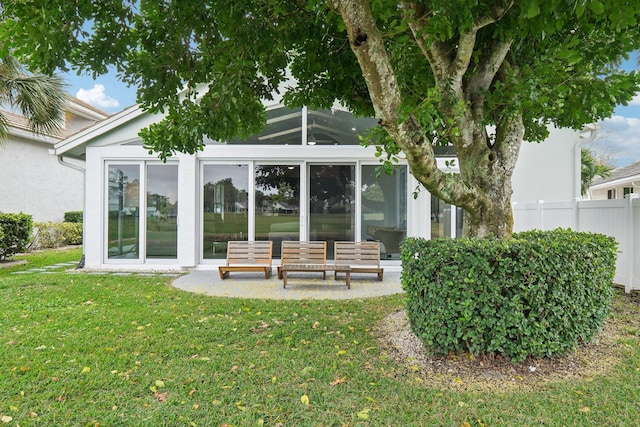 back of property featuring a yard and a sunroom