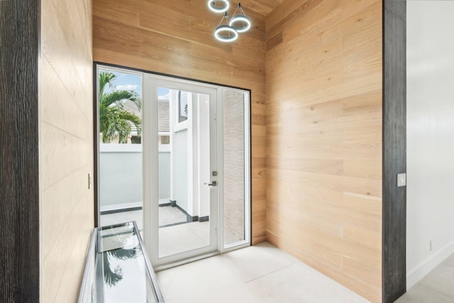 doorway with tile patterned floors, wooden ceiling, and wood walls