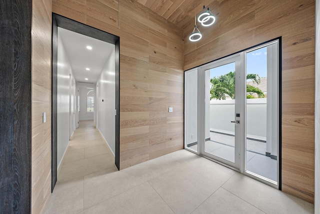 doorway to outside with wooden ceiling, wooden walls, and light tile patterned flooring