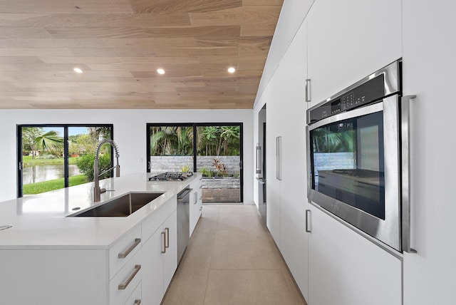 kitchen featuring light tile patterned flooring, sink, white cabinetry, wood ceiling, and appliances with stainless steel finishes