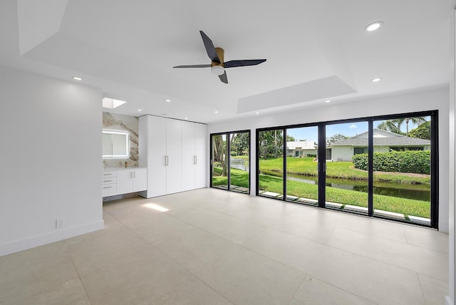 interior space with a tray ceiling and ceiling fan