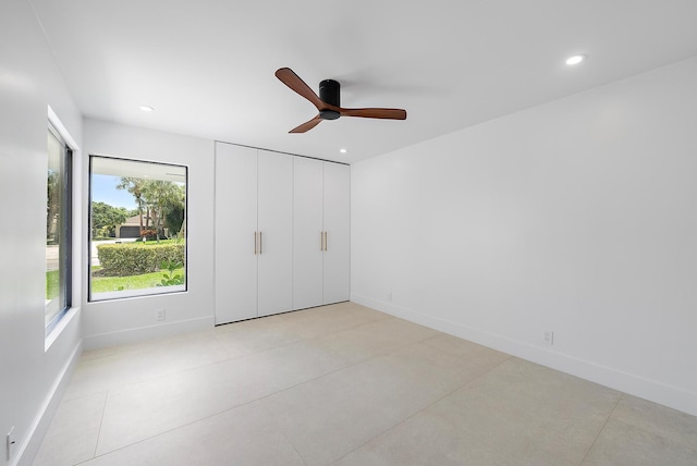 unfurnished bedroom with ceiling fan, light tile patterned floors, and a closet