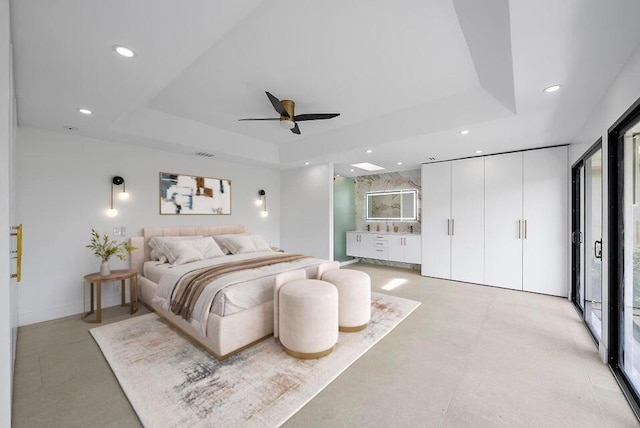 bedroom with ceiling fan, a tray ceiling, and multiple windows