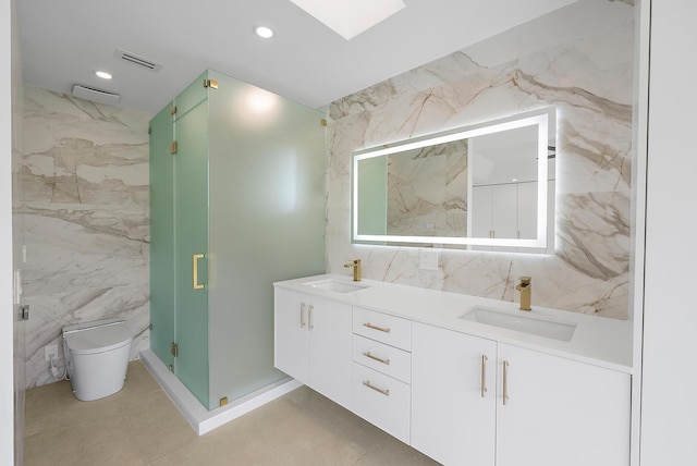 bathroom with tile walls, vanity, toilet, and walk in shower