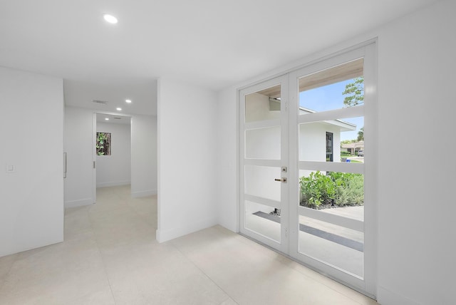 spare room featuring french doors, light tile patterned floors, and a wealth of natural light