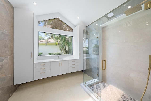 bathroom with an enclosed shower, tile patterned flooring, lofted ceiling, and tile walls