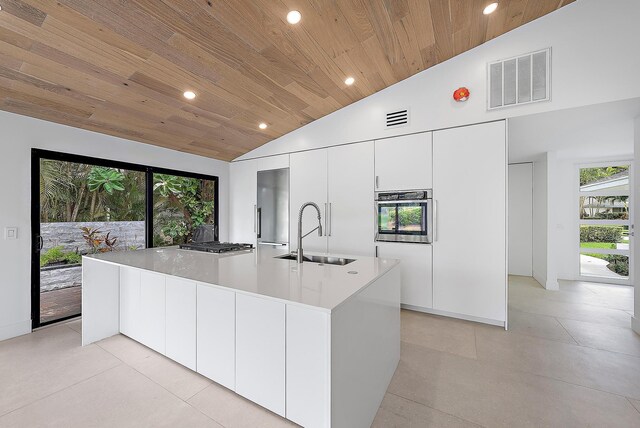 kitchen featuring ceiling fan, white cabinetry, and wood ceiling