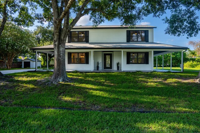 farmhouse-style home featuring covered porch, an outdoor structure, and a front lawn