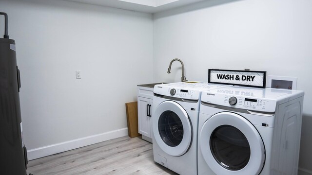 laundry area with independent washer and dryer, light hardwood / wood-style flooring, and cabinets