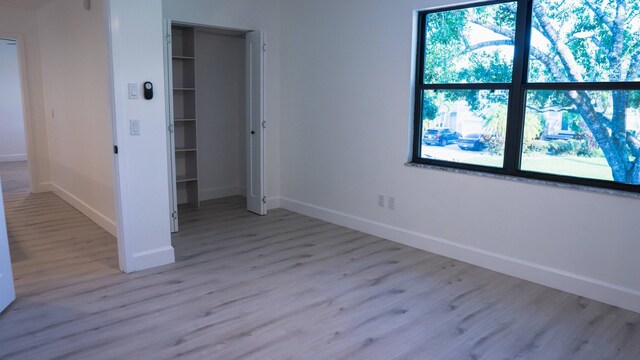 unfurnished bedroom with a closet and light wood-type flooring