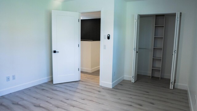 unfurnished bedroom featuring a closet and light hardwood / wood-style floors