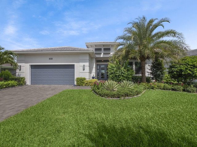 view of front of home with a garage, a front yard, and french doors