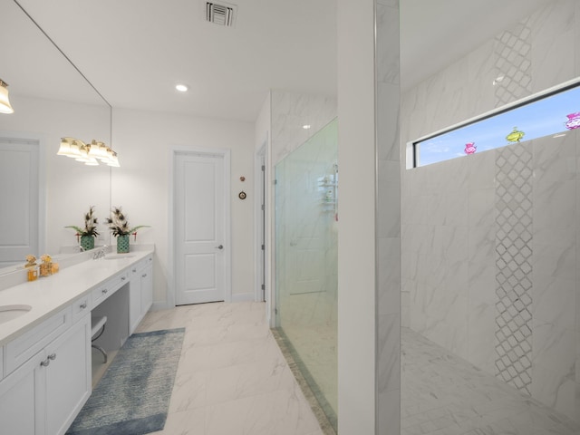 bathroom with tiled shower and vanity