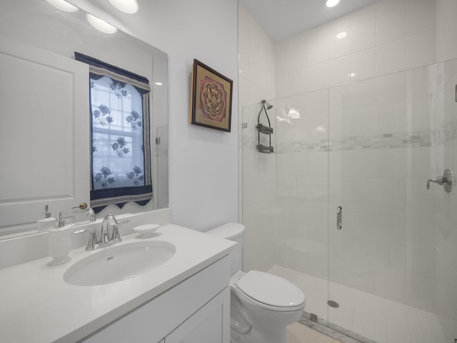 bathroom featuring vanity, toilet, and a shower with shower door