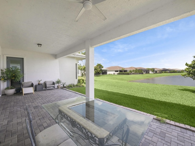 view of patio / terrace featuring ceiling fan and a water view