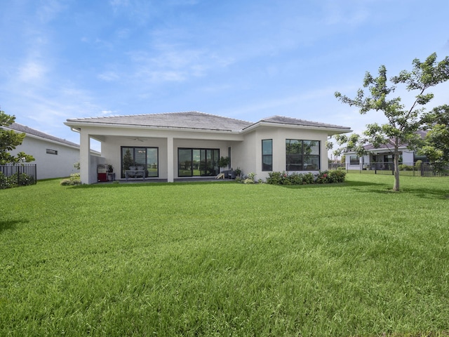 back of house featuring a yard and ceiling fan