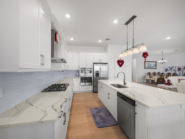 kitchen featuring white cabinetry, stainless steel appliances, and a large island with sink