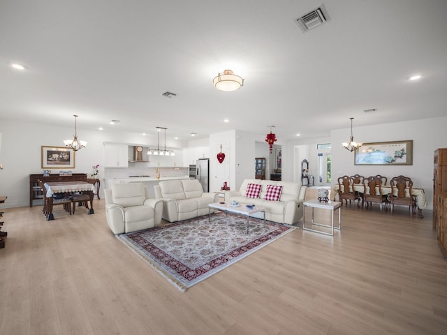 living room with a notable chandelier and light hardwood / wood-style floors