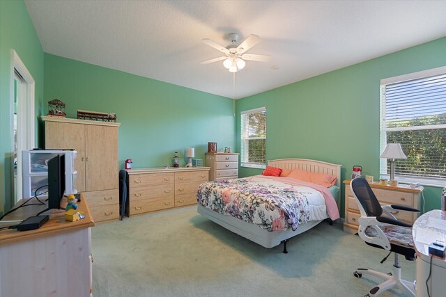 carpeted bedroom with multiple windows and ceiling fan