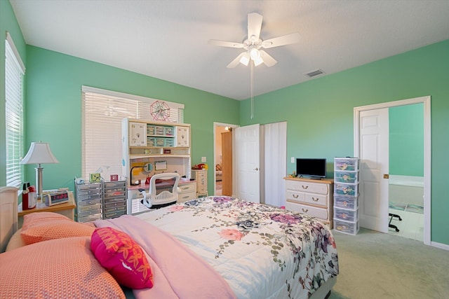 carpeted bedroom featuring ceiling fan and ensuite bath