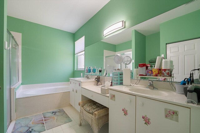 bathroom with tile patterned flooring, a bathing tub, and double vanity