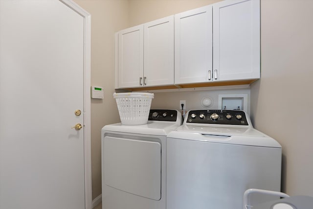 clothes washing area featuring independent washer and dryer and cabinets