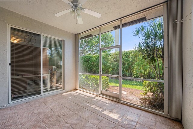 unfurnished sunroom with ceiling fan