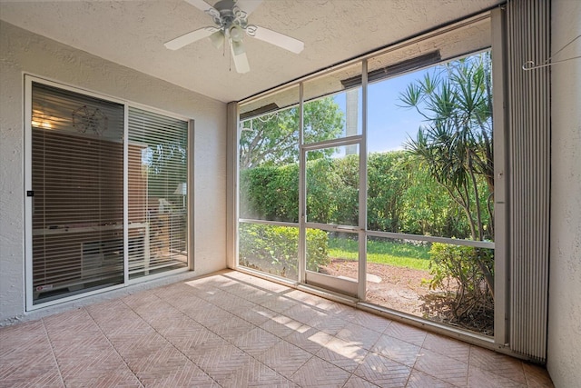 unfurnished sunroom featuring ceiling fan