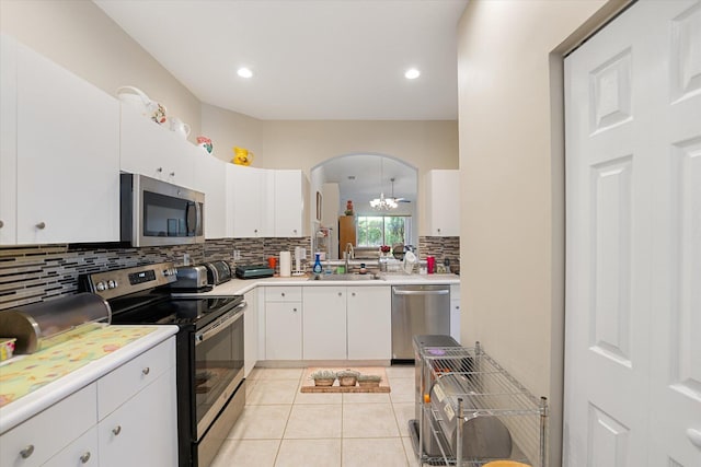 kitchen with stainless steel appliances, white cabinetry, sink, and light tile patterned floors