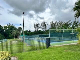 view of tennis court with a lawn