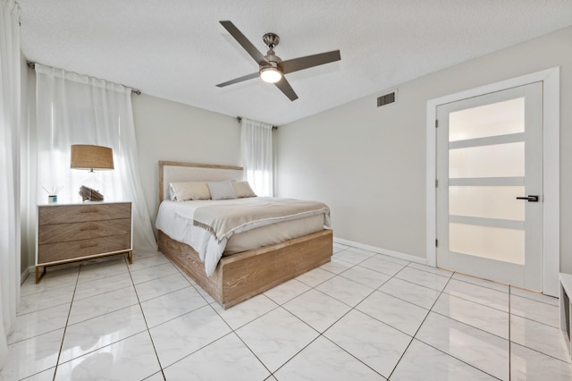 bedroom with ceiling fan and a textured ceiling