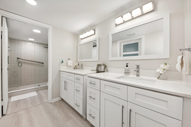 bathroom featuring hardwood / wood-style floors, vanity, and a shower with shower door