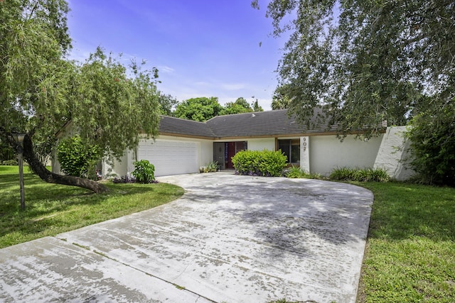 single story home with a garage and a front lawn