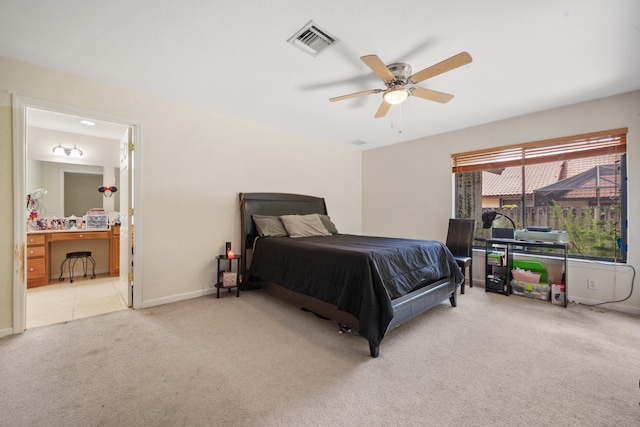 carpeted bedroom with ensuite bath and ceiling fan